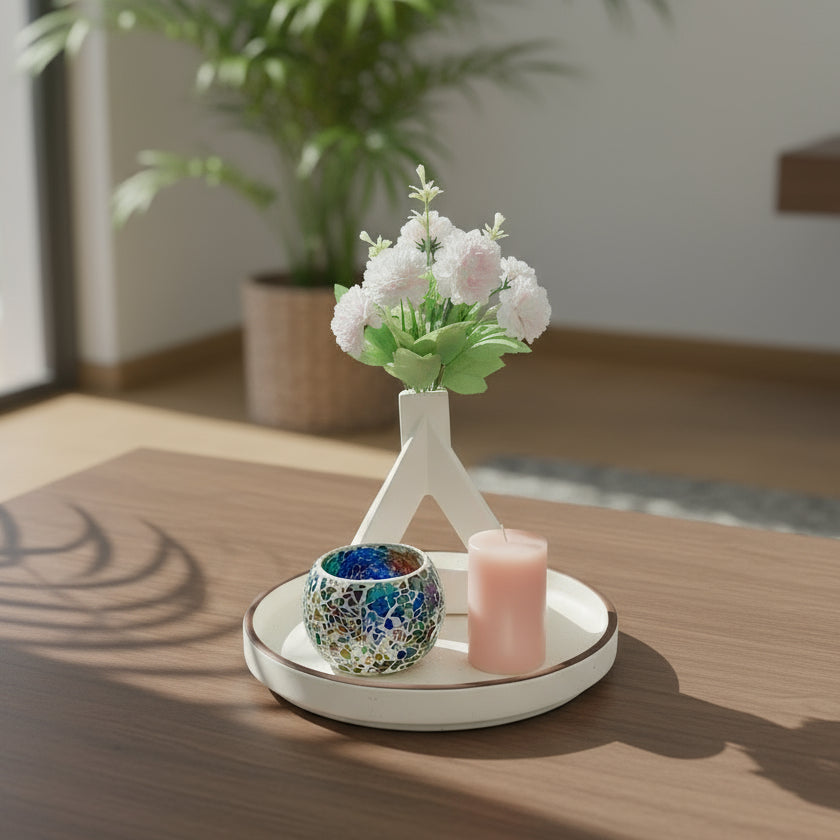 Decorative items including a vase with flowers, a colorful bowl, and a pink candle on a table.