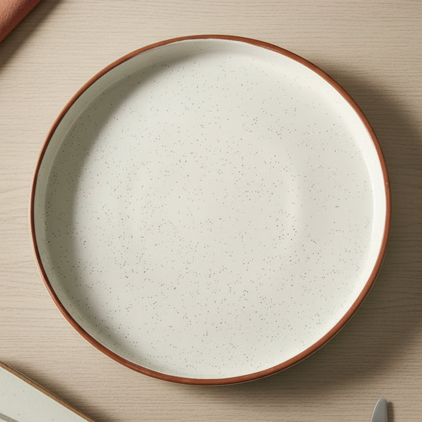 Round ceramic plate with a brown rim on a dark surface