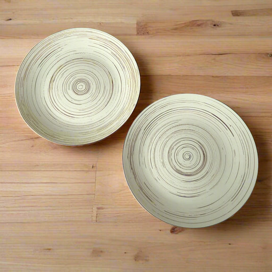Two round ceramic bowls with concentric circle patterns on a wooden surface