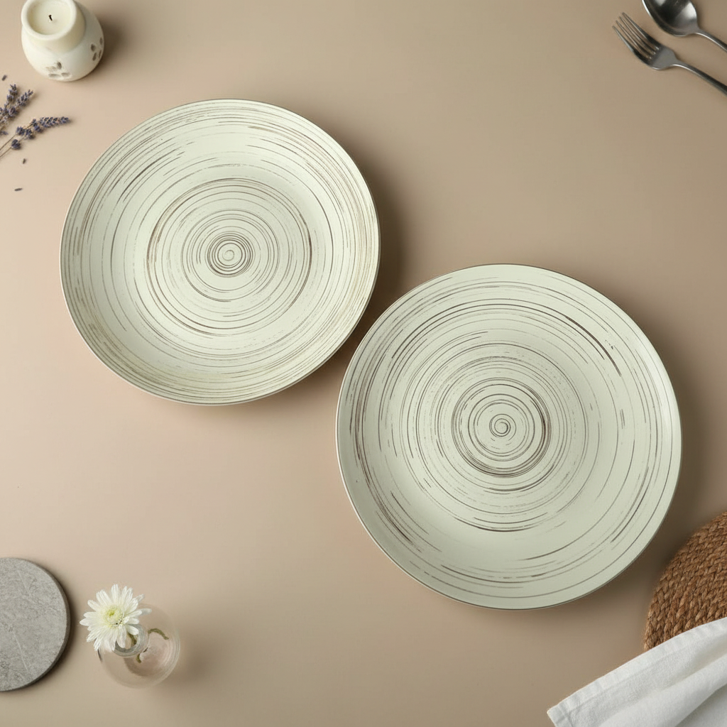Two ceramic plates with concentric circle design on a beige surface.
