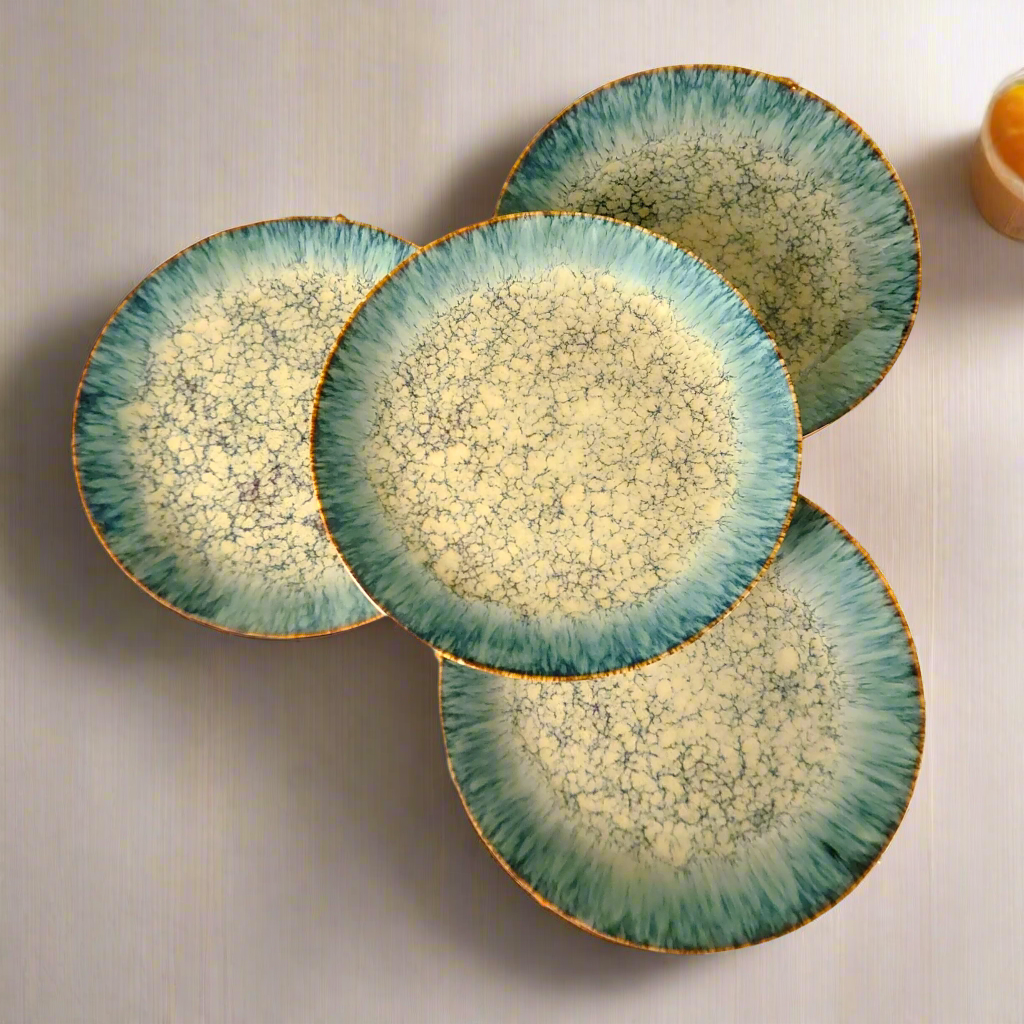 Set of four ceramic plates with a textured green and beige design on a light background