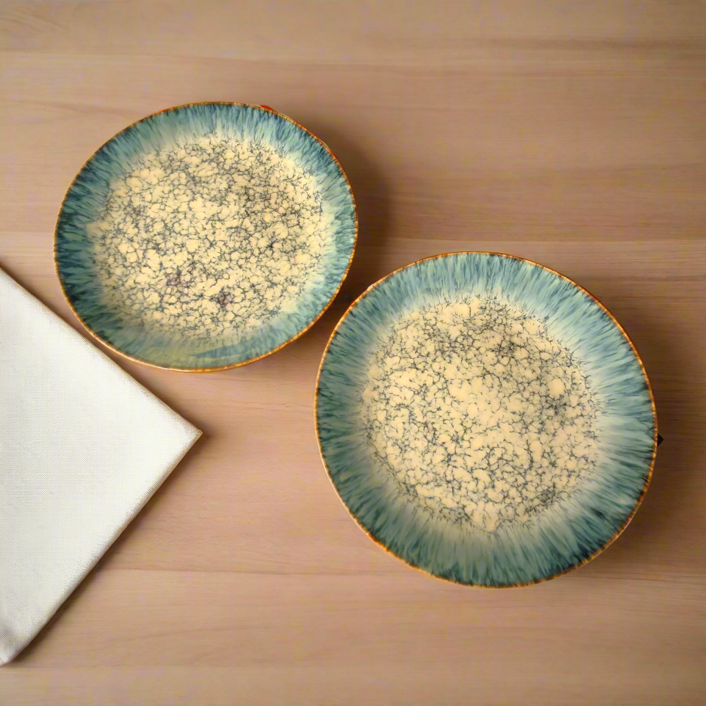 Two ceramic plates with a textured surface on a wooden table.