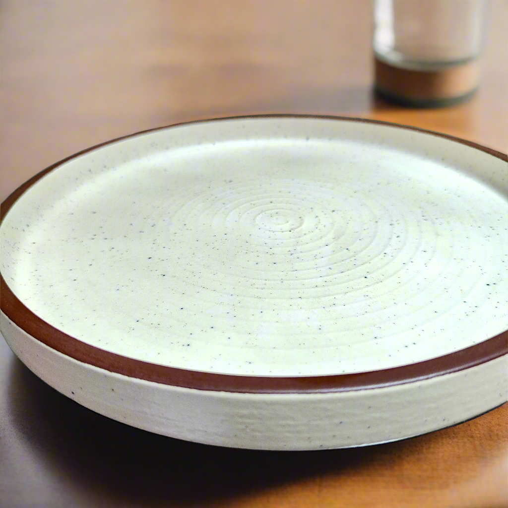 White ceramic plate with brown rim on a wooden surface
