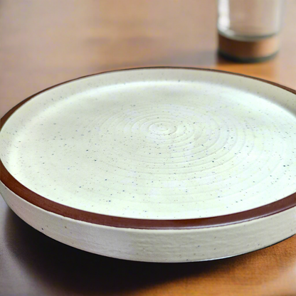White ceramic plate with brown rim on a wooden surface